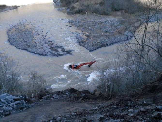 Irmağa yuvarlanan iş makinesinin operatörü yaralandı
