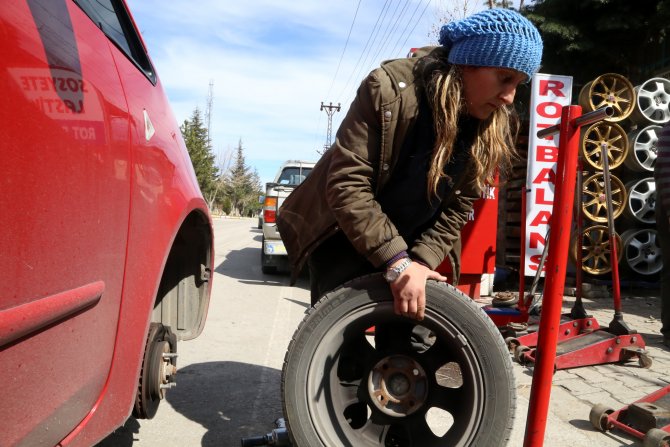 Kocasının yanında lastik tamir ediyor