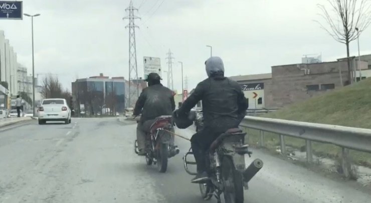 Kasksız motosikletli, yakıtı biten başka bir motosikleti iple çekti