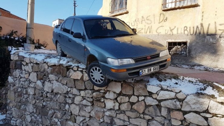 Buzlanmadan dolayı kayan otomobil duvar üzerinde asılı kaldı