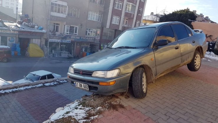 Buzlanmadan dolayı kayan otomobil duvar üzerinde asılı kaldı