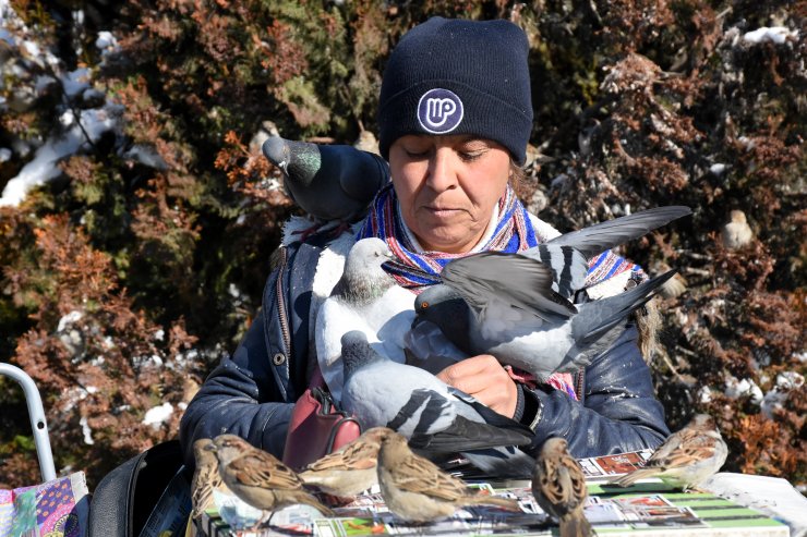 Başına konan "talih kuşları" ile insanlara şans dağıtıyor