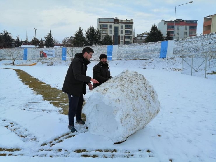 Sporcular çim sahada kar küredi