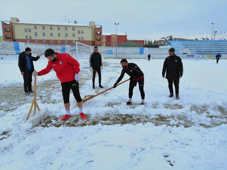 Sporcular çim sahada kar küredi